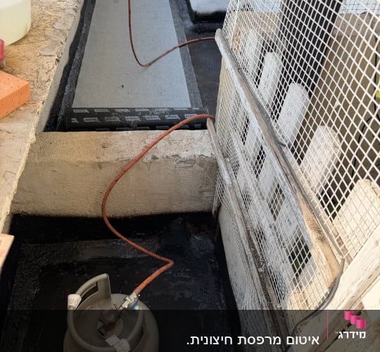 עבודת איטום עם יריעות ביטומניות ומיכל גז